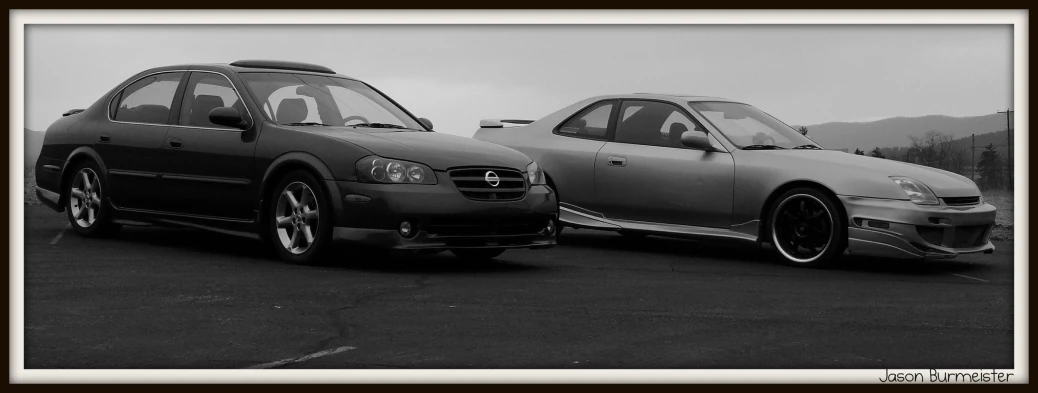 two cars with silver tires parked in the parking lot