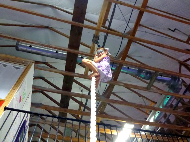 the man is climbing a high rope in an indoor climbing area
