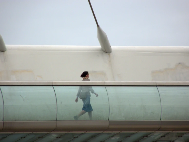 a girl walking across a walkway under an electronic walkway