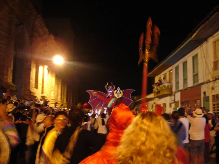 a crowd of people stand in a dark city street