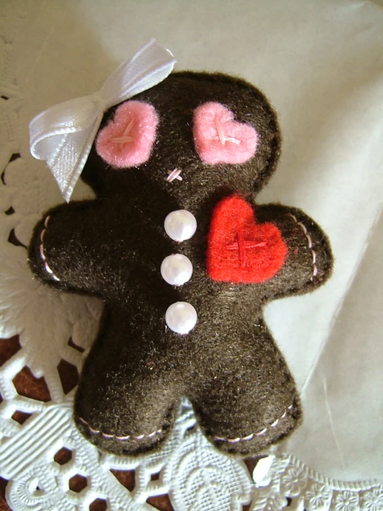 a teddy bear with two pink heart shaped patches