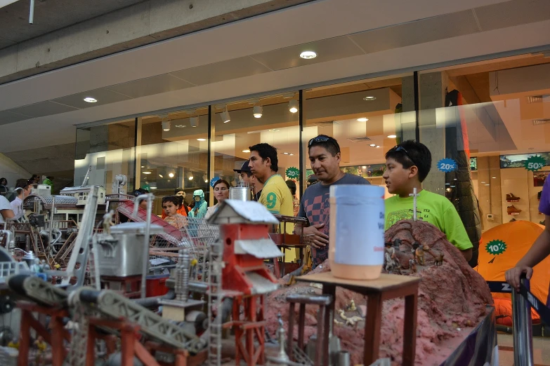 several people standing in front of a building, some working with paper