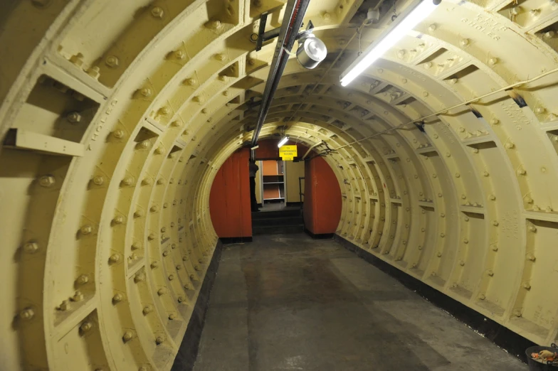 a very long tunnel with lights and concrete floor