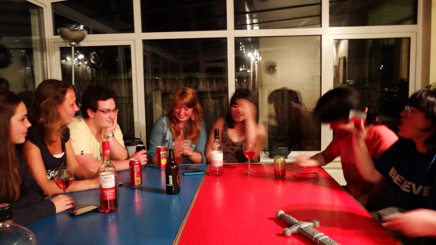 five young people sit at a table, all smiling