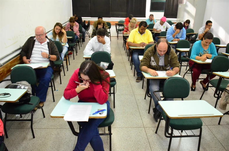 there are many people sitting at the desks in the room