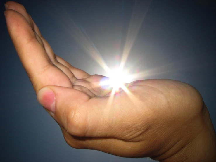 the hand of a person holding soing is shining bright