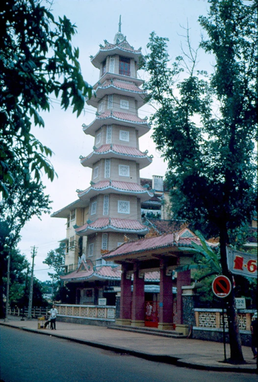 a tall pagoda like building on the side of a road