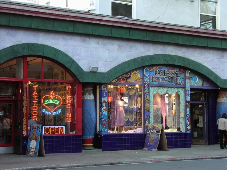 several storefronts with neon lights adorn a street