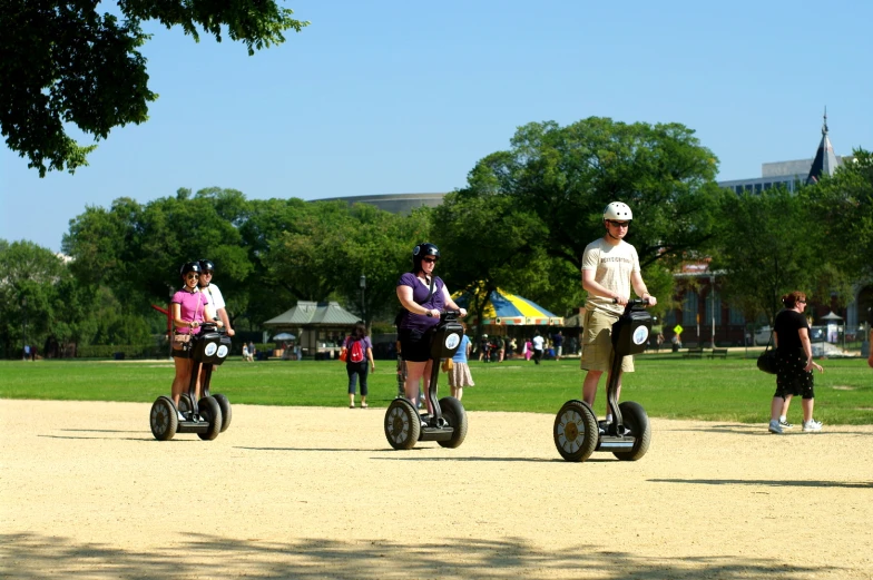 the two people are riding segways on the trail in the park