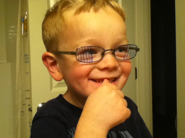 a small boy wearing glasses is making a funny face