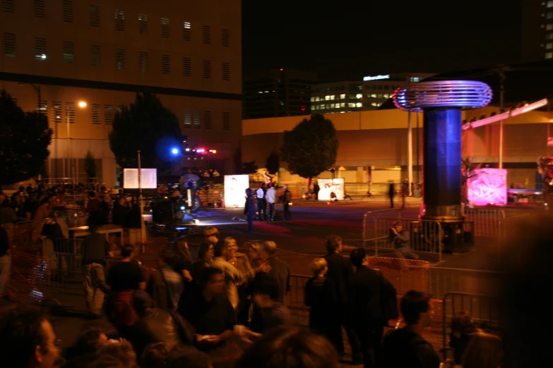 several people standing in a circle, and watching some people play