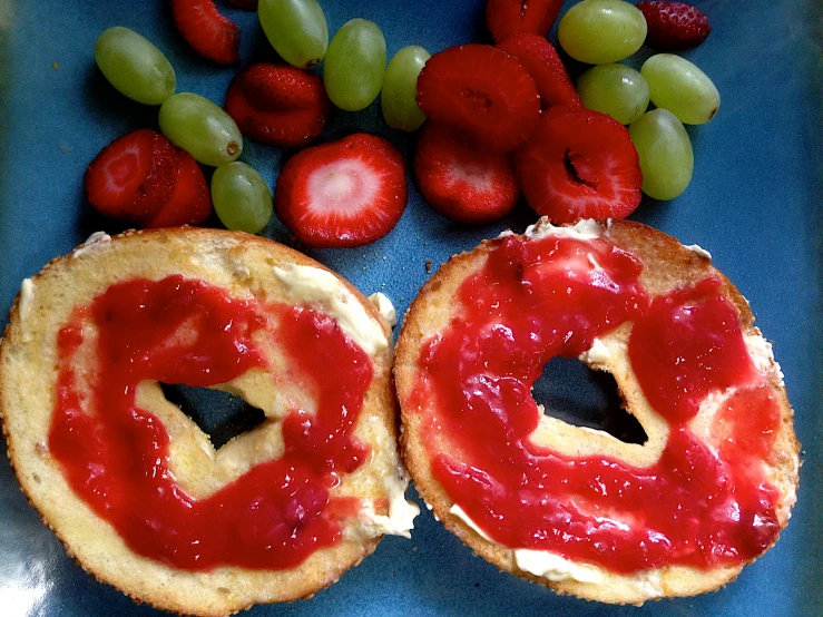 a blue plate topped with two small pies covered in strawberry jam