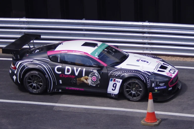 an audi racing car on a road next to a traffic cone