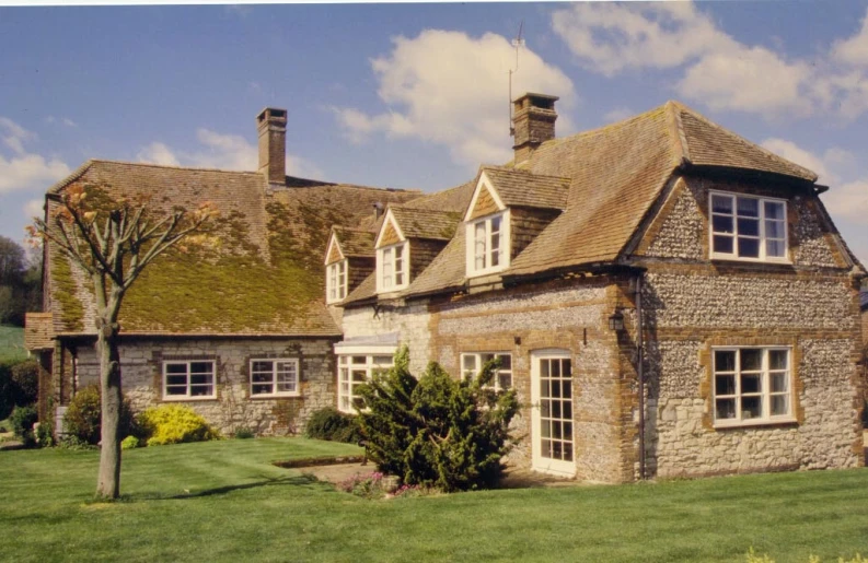 a building sitting next to a green field