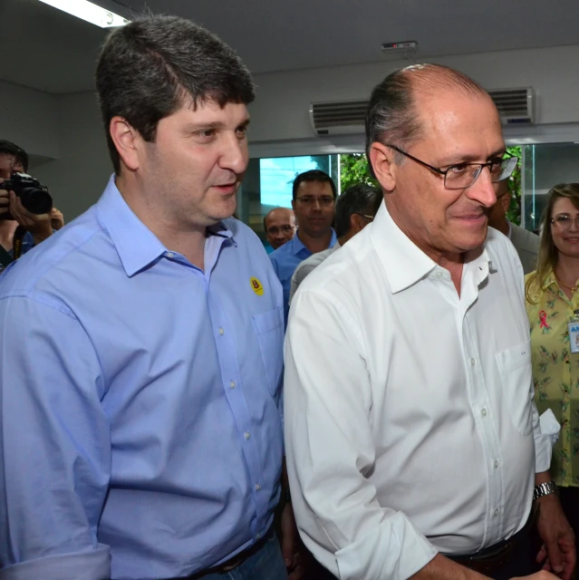 man in white shirt talking to two other men