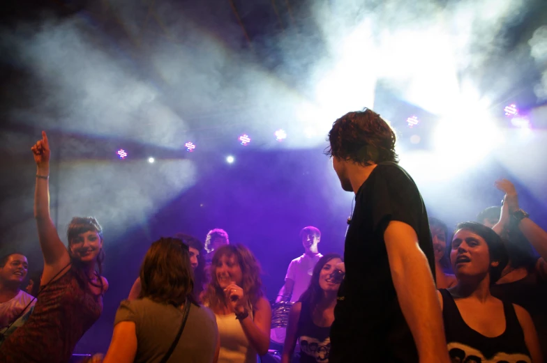 a man dancing on a danceflossy stage surrounded by other people