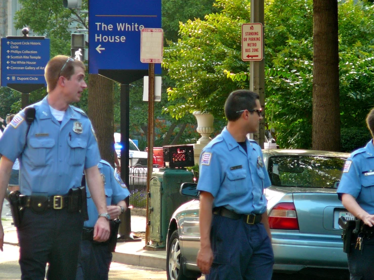 two police officers are walking together down the sidewalk