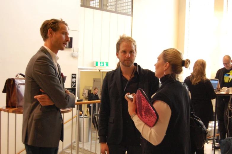 a man is standing next to a woman with her arm in an open jacket