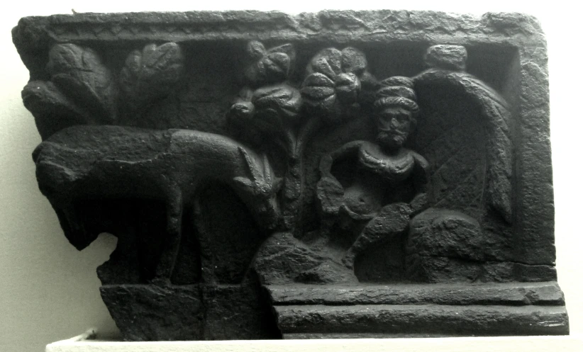 a carving depicting figures and a deer on a wall