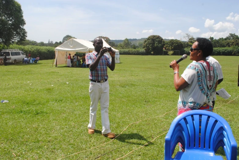 man and woman stand in field playing music