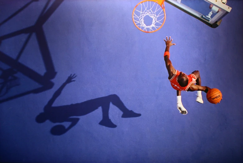 a man dunking a basketball in an indoor court