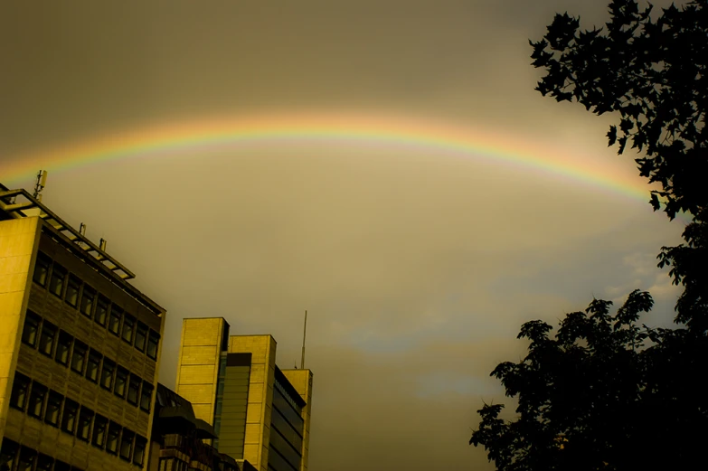 a rainbow in the sky near some buildings