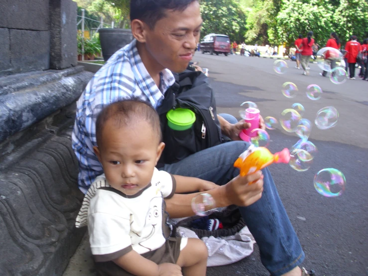 a  playing with bubbles while sitting on the side of the road