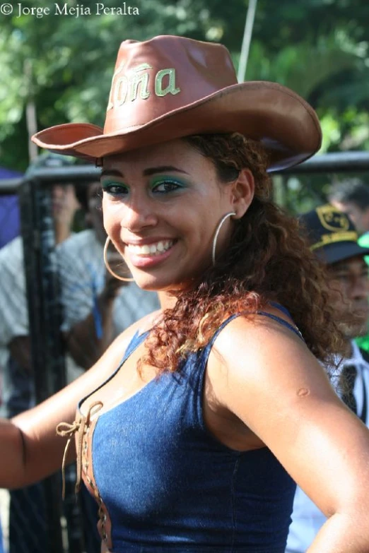 a woman wearing a cowboy hat and blue dress