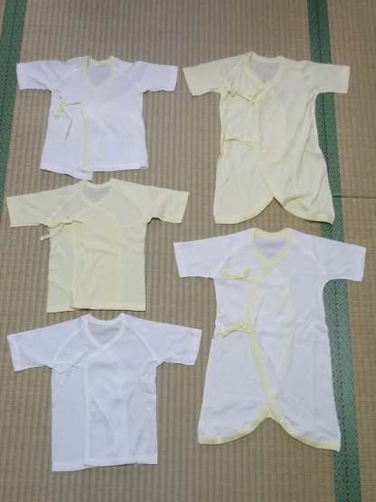 an image of five different baby clothes laid out