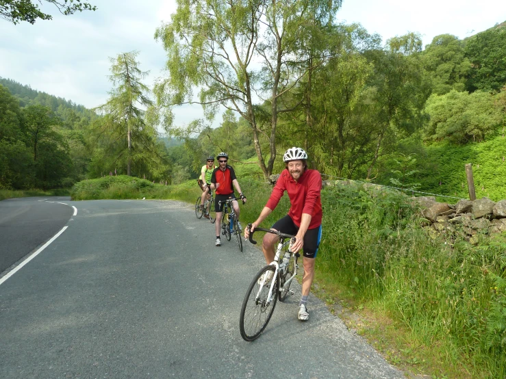 four bikers riding bikes on the road in a row