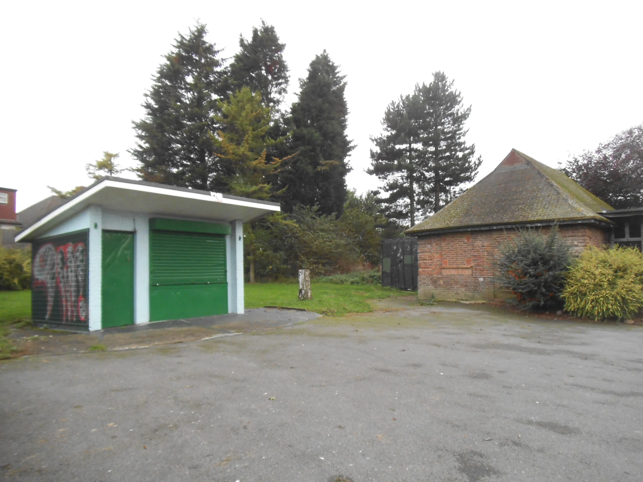 an image of a parking lot with a building and a green garage