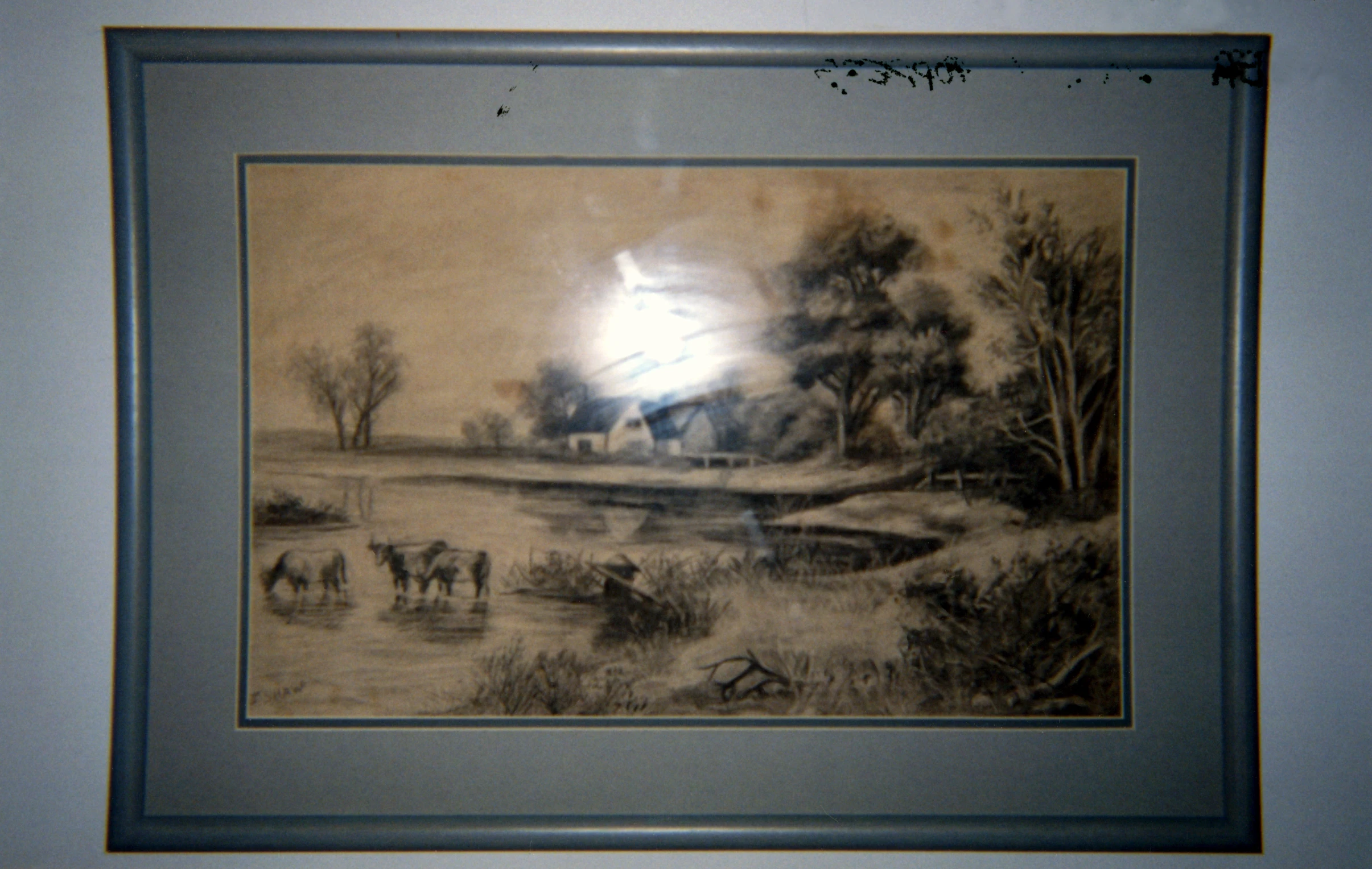 a painting is on display near a painting of cattle in the wilderness