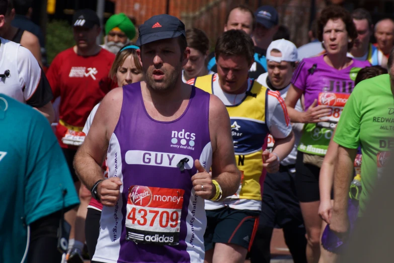 a man in purple vest running a marathon