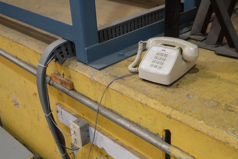 there is an old telephone sitting on the edge of the window