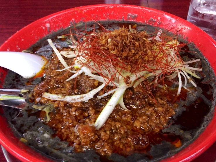 a red plate topped with rice covered meat