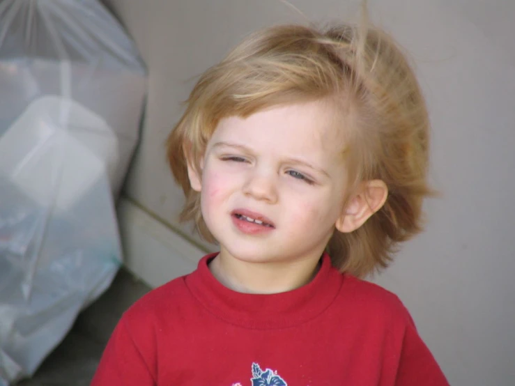 a close - up of a little girl's face with a messy top knot