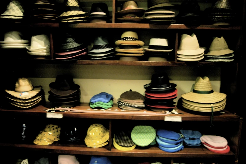 a collection of different hats are sitting on wooden shelves