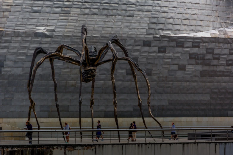 large spider sculpture on display next to the river