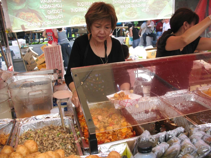 two women and one is serving some food