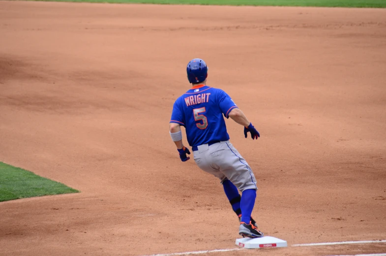 a man running around a base on a baseball field