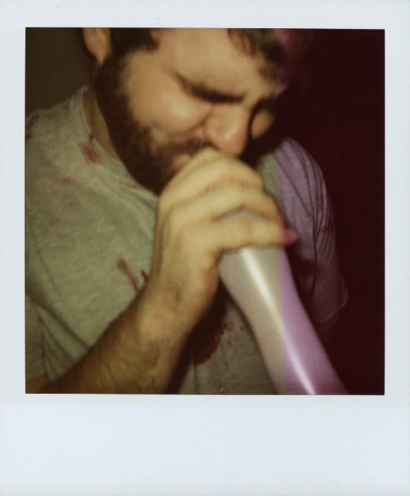 a man with beard and shirt is brushing his teeth