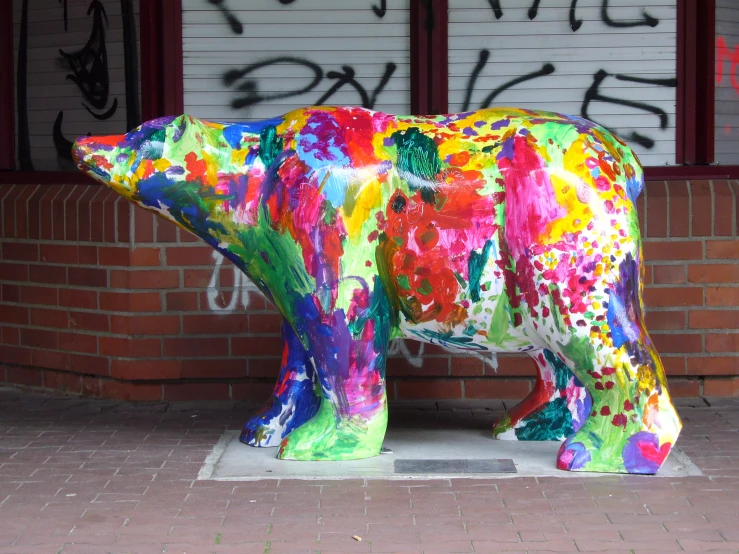 a bear statue in front of a building covered in graffiti