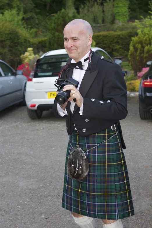 a man in kilt taking a po with his camera