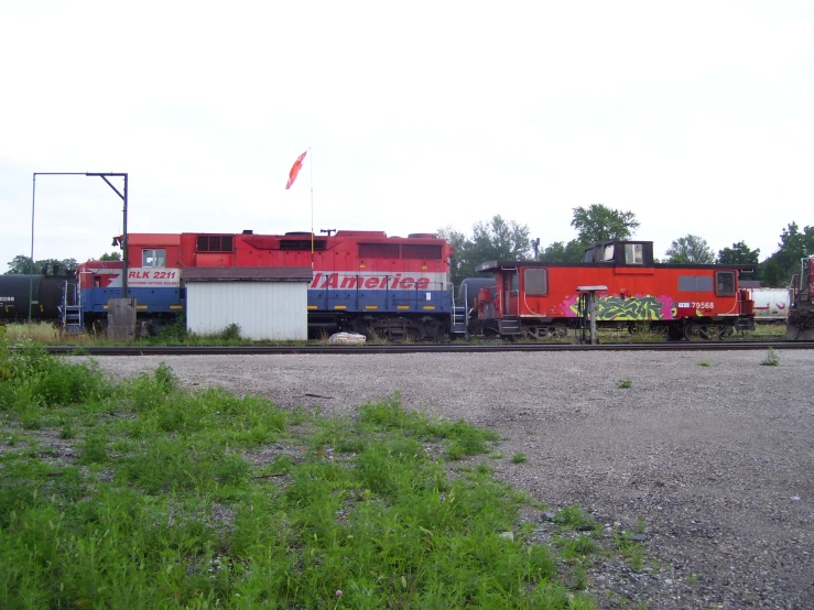 the train cars are sitting out on the railroad tracks