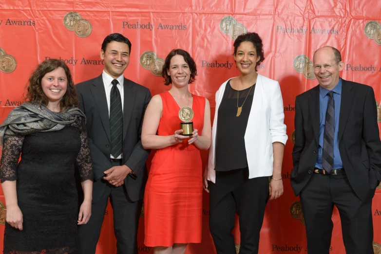 some people standing in front of a wall with some awards