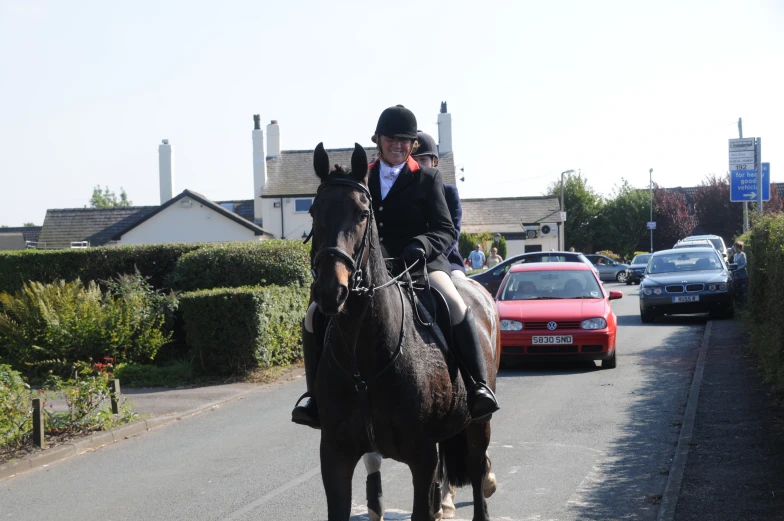 there is an equestrian wearing a suit and tie riding on a horse