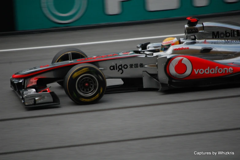 a silver race car drives down a racetrack