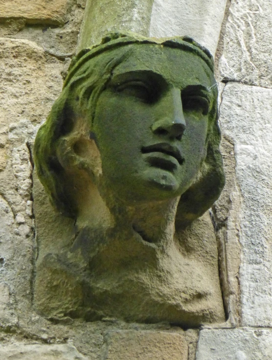 an abstract head on the side of a brick building