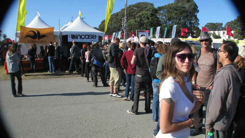 a woman in sunglasses standing next to a line of people