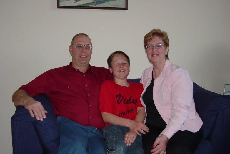 a  and woman sitting on a couch with a male and female